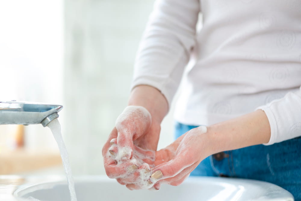 Como trabalhar durante a pandemia: mulher lavando bem suas mãos.